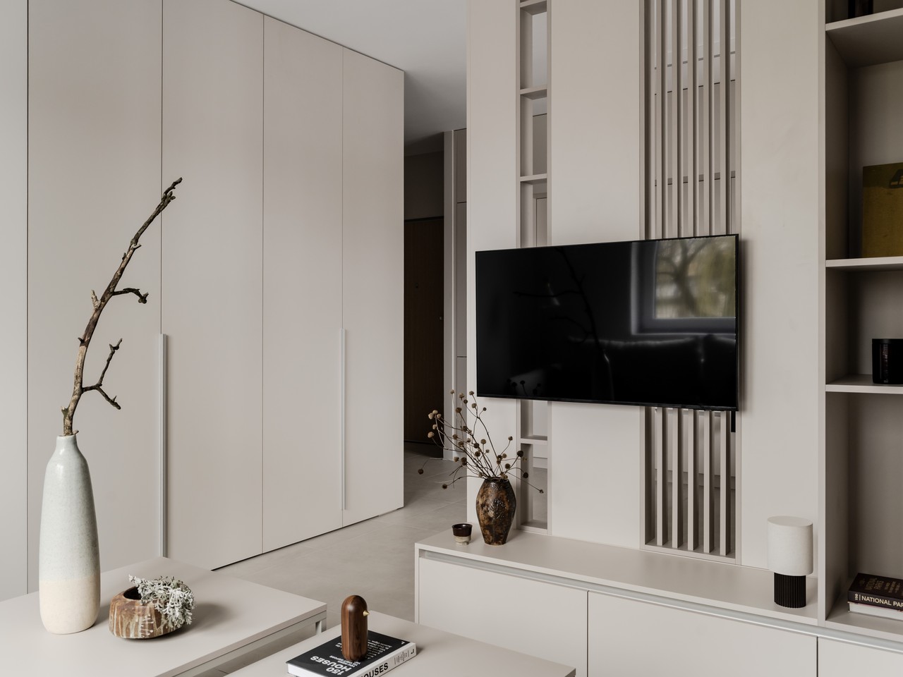 Minimalistyczne wnętrze z eleganckim telewizorem na jasnej ścianie.