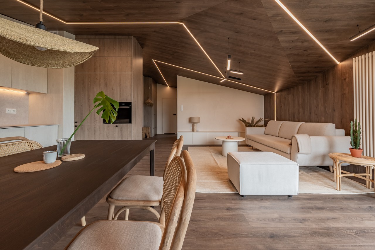 Nowoczesny salon z drewnianymi elementami i eleganckim oświetleniem.