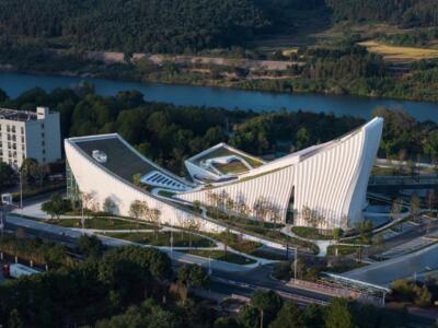 Nowoczesna architektura z organicznymi formami nad rzeką.