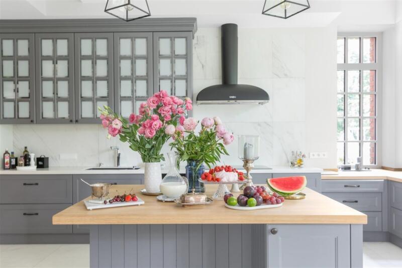 Modern kitchen with flowers and fruit on a wooden countertop.