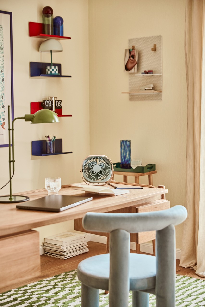 Przytulne biuro z designerskimi meblami i pastelowymi dodatkami.