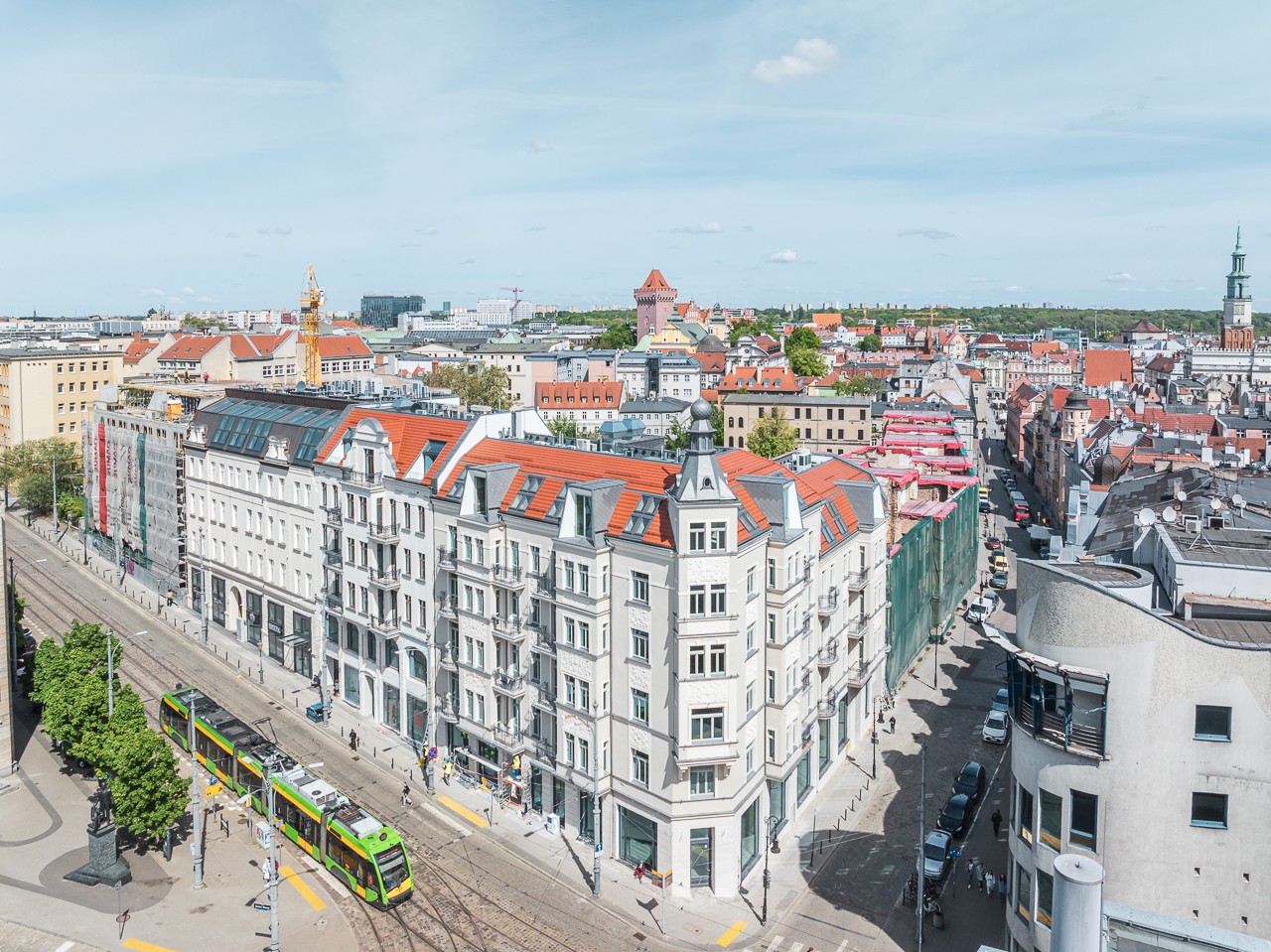 Historyczna architektura miasta z tramwajem i czerwonymi dachami.