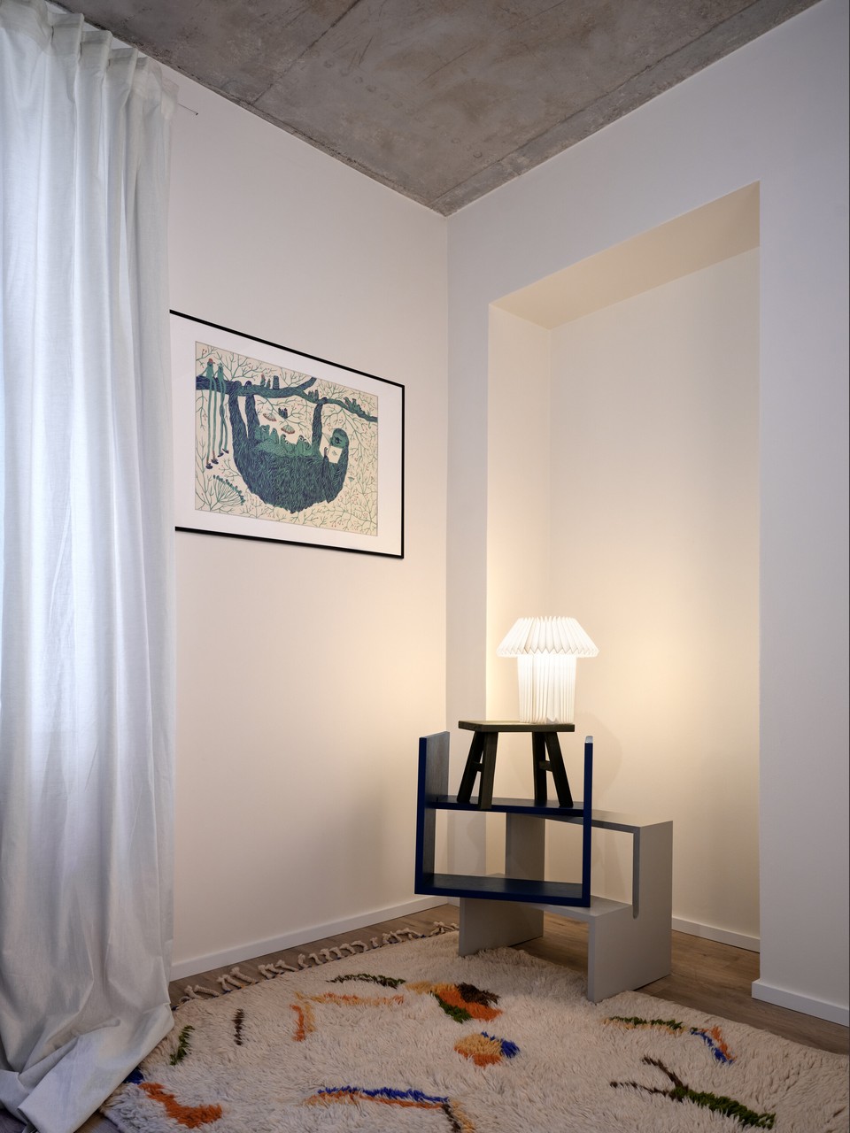Przytulny kącik z designerską lampą i sztuką na ścianie.