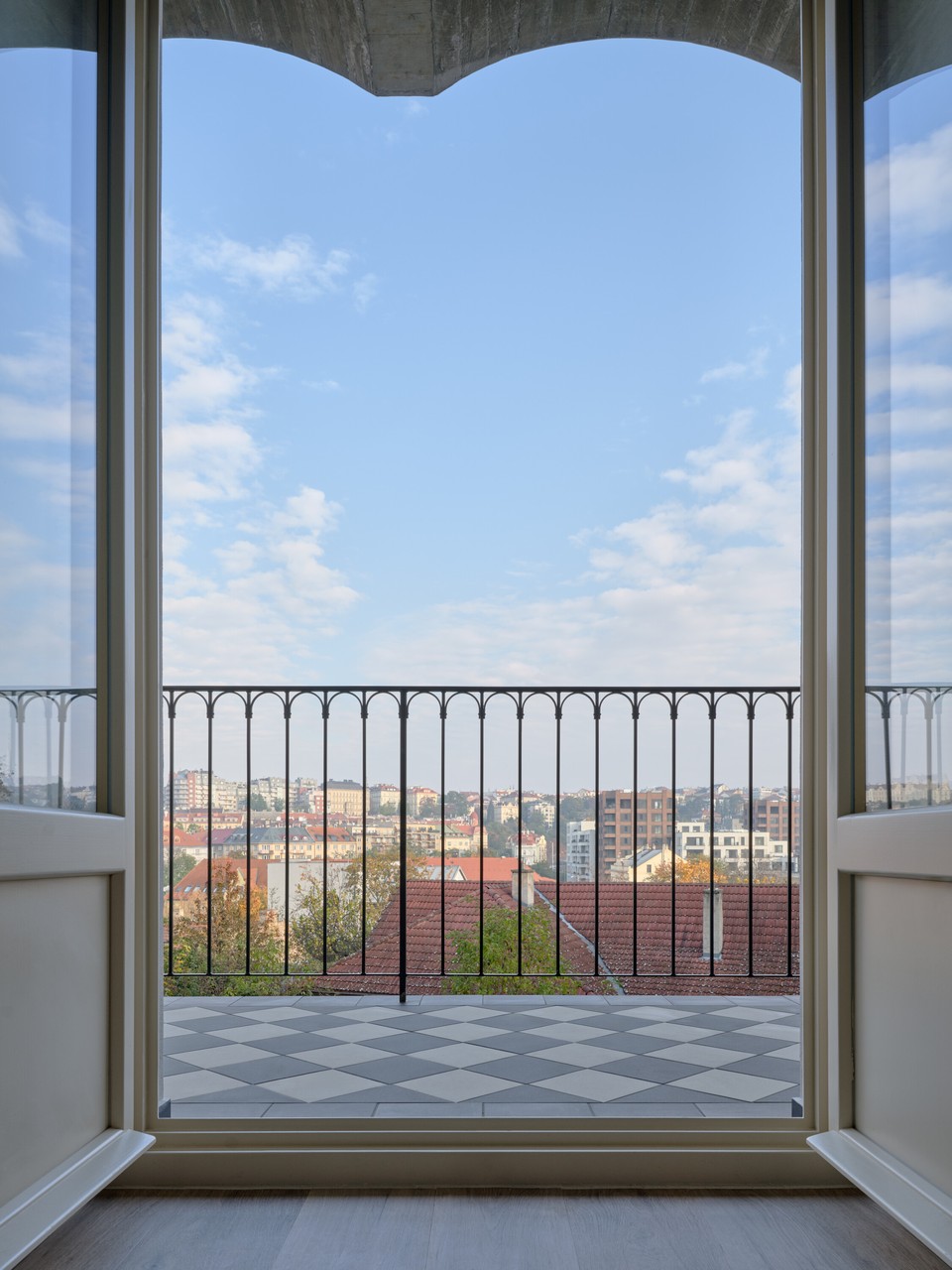 Widok na miasto z balkonu z elegancką balustradą i wzorem kafli.