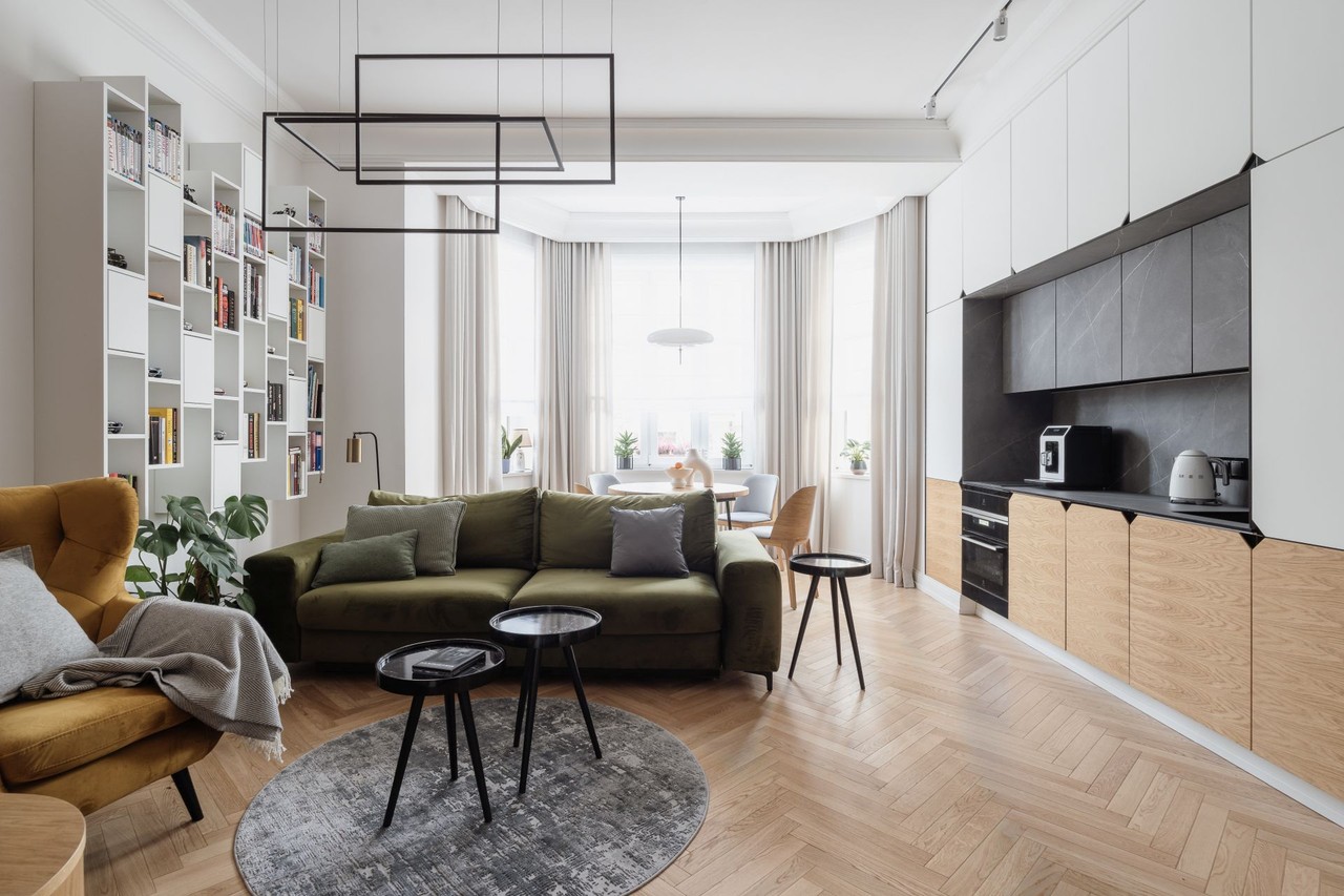 Modern living room with green sofa and designer kitchen.
