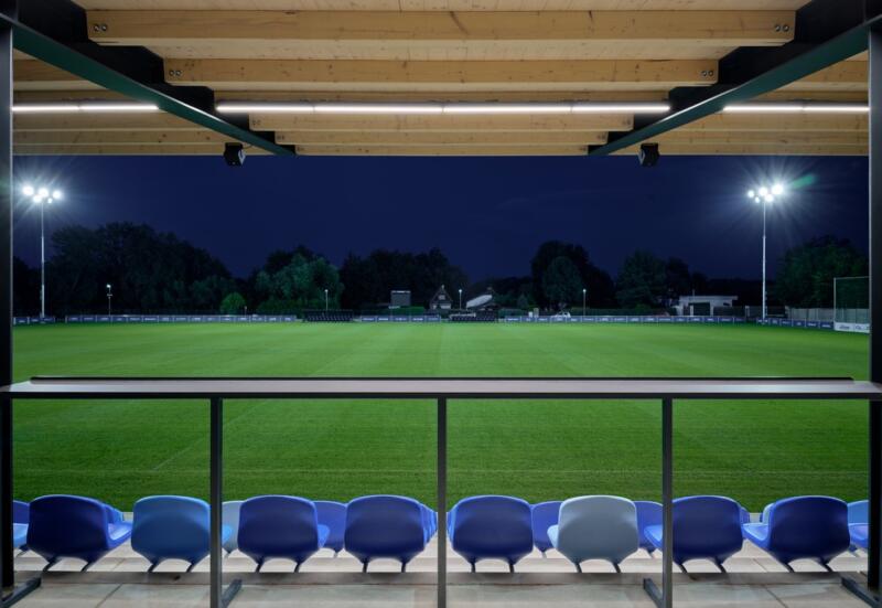 Nowoczesne oświetlenie stadionu z drewnianym zadaszeniem.