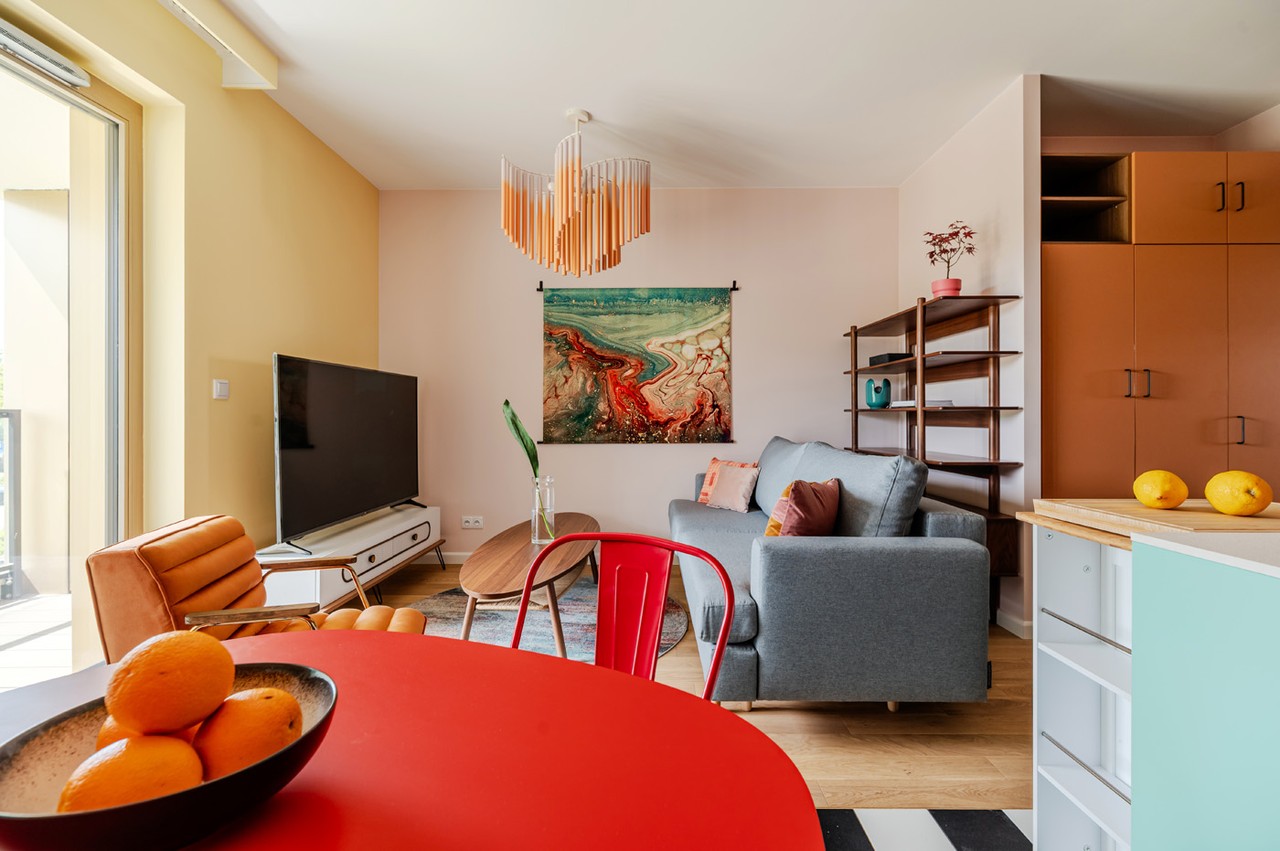 Nowoczesny salon z kolorowymi akcentami i designerskim oświetleniem.