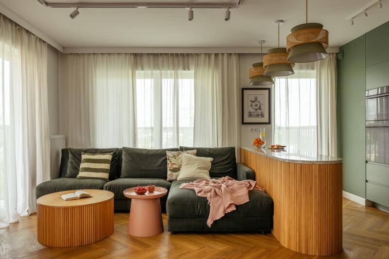 Stylowy salon z zieloną kanapą i eleganckimi lampami.