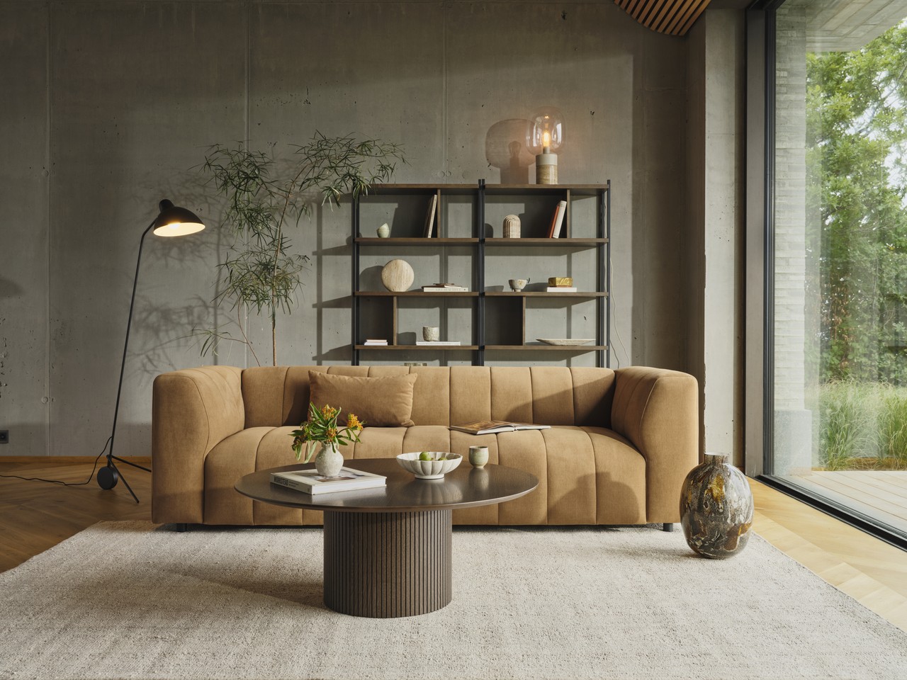 Nowoczesny salon z brązową sofą i designerskim oświetleniem.
