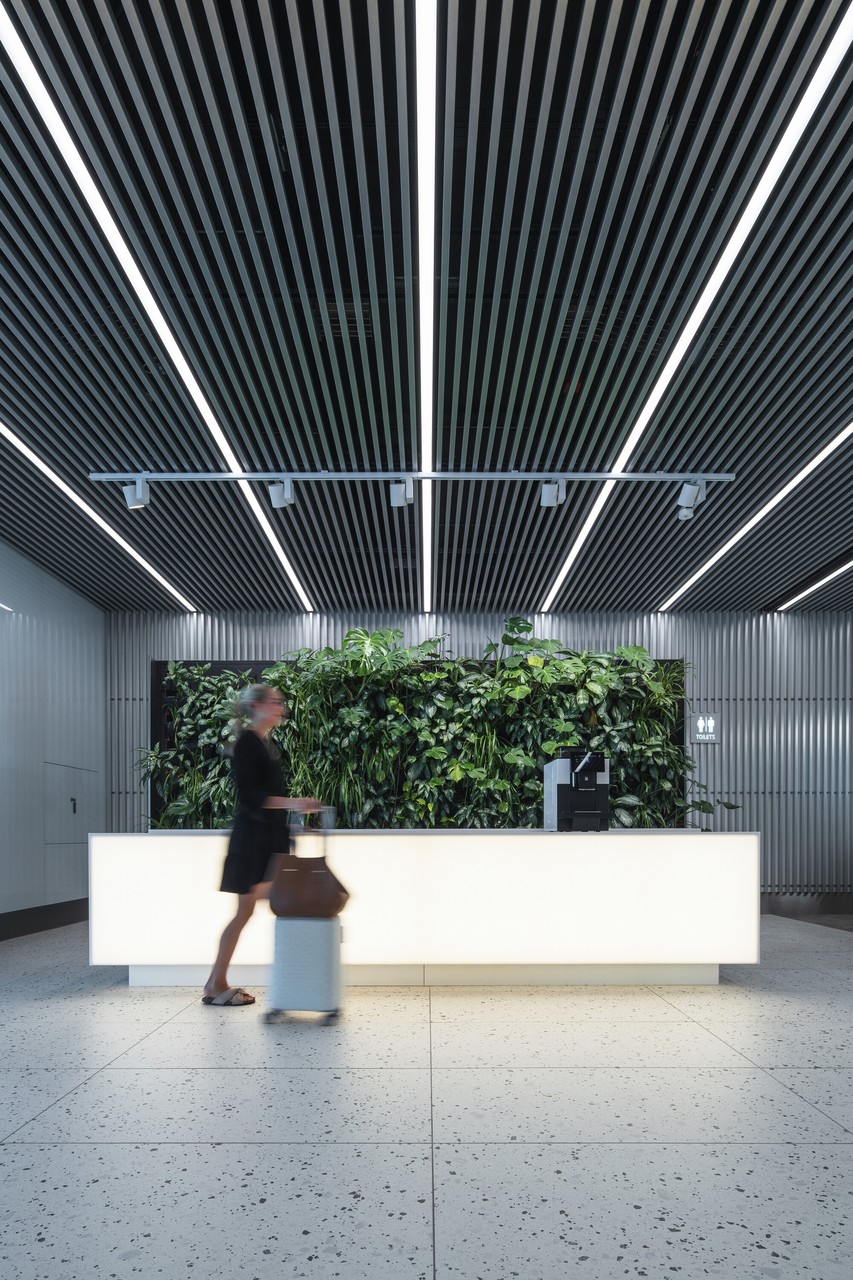 Nowoczesne lobby z zieloną ścianą i oświetleniem LED.