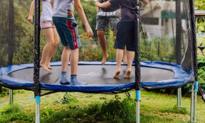 Dzieciństwo na trampolinie w przydomowym ogrodzie.