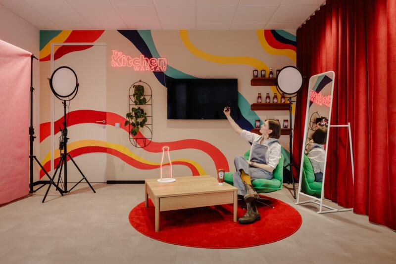 Stylowy salon z kolorową ścianą i nowoczesnym oświetleniem.