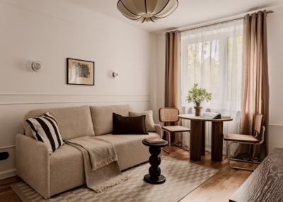 Elegancki salon z beżową sofą i stylowym wystrojem.