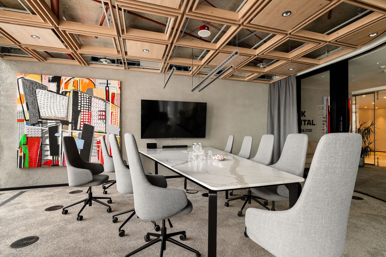 Nowoczesna sala konferencyjna z designerską sztuką i wygodnymi krzesłami.