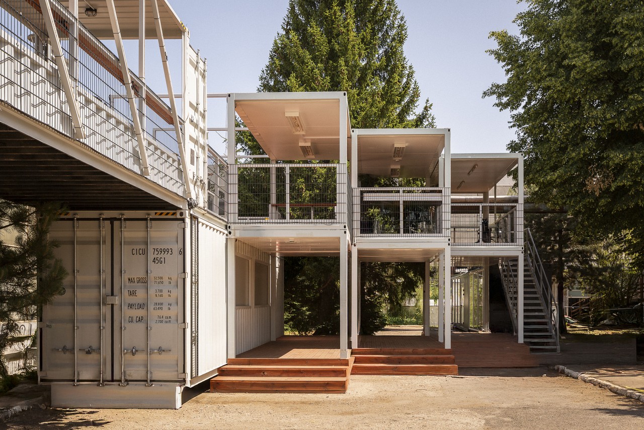 Nowoczesna architektura z kontenerów w otoczeniu zieleni.