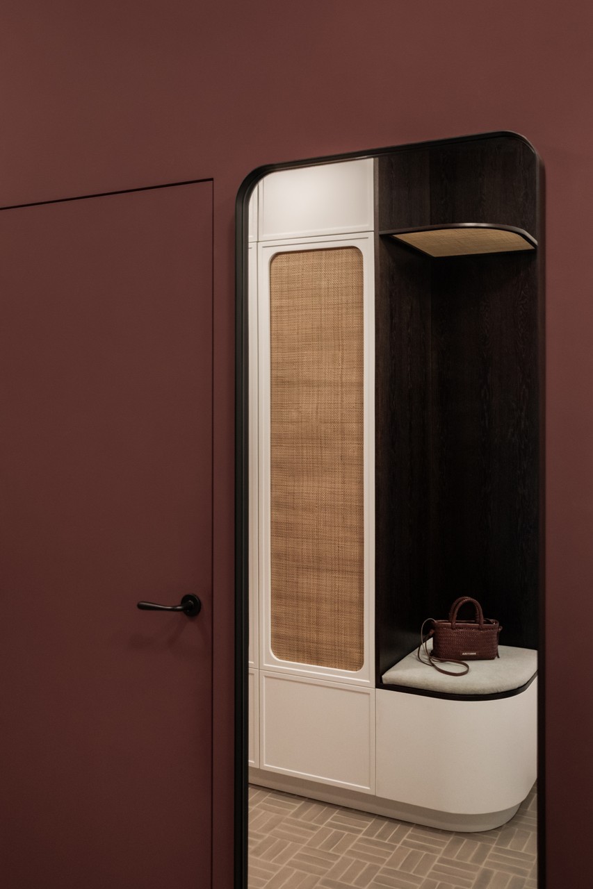 Ciemne wnętrze z eleganckim, nowoczesnym detalem i wkomponowanym siedziskiem.