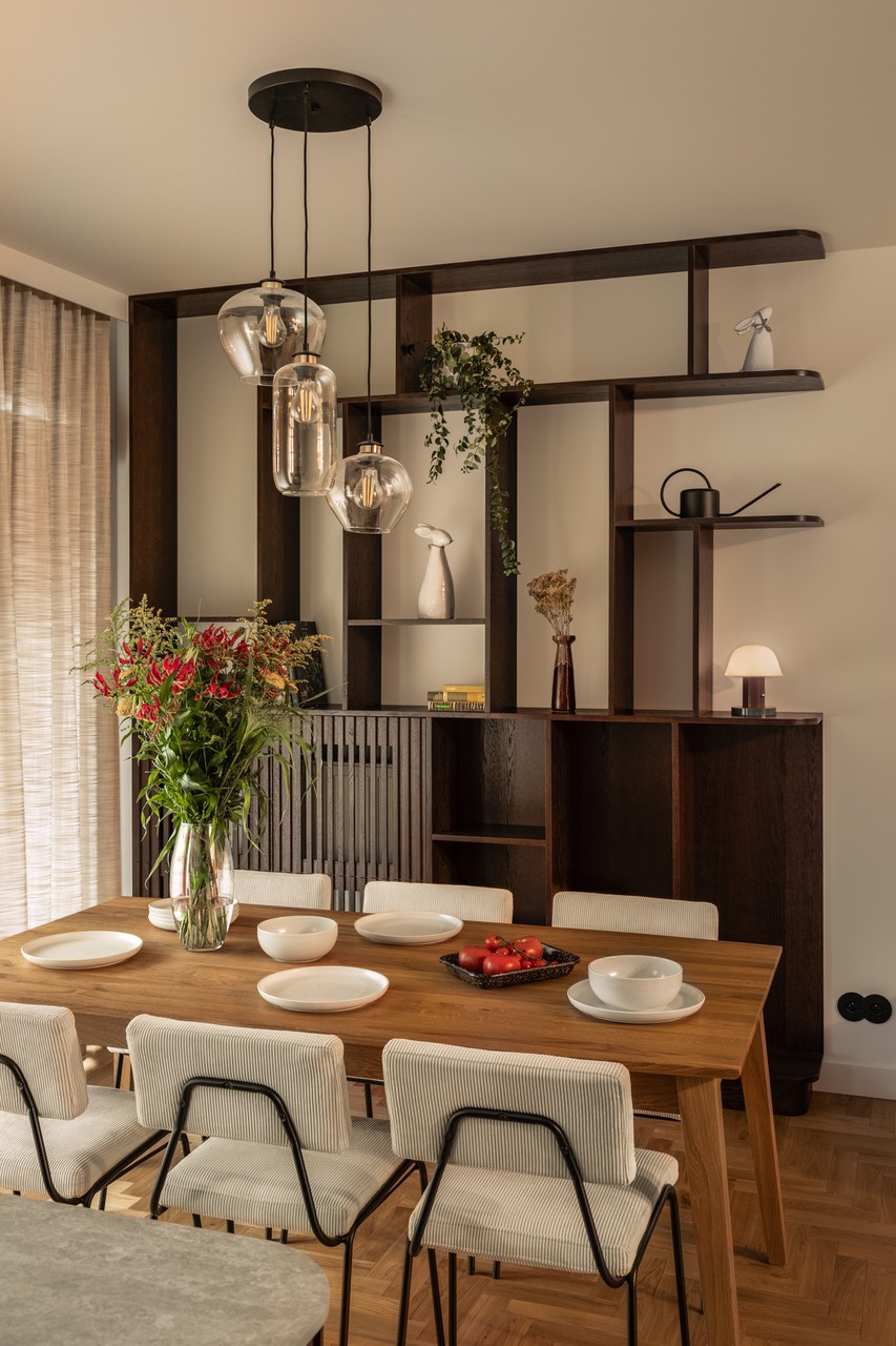 Stół z eleganckimi krzesłami i stylową lampą w nowoczesnym wnętrzu.