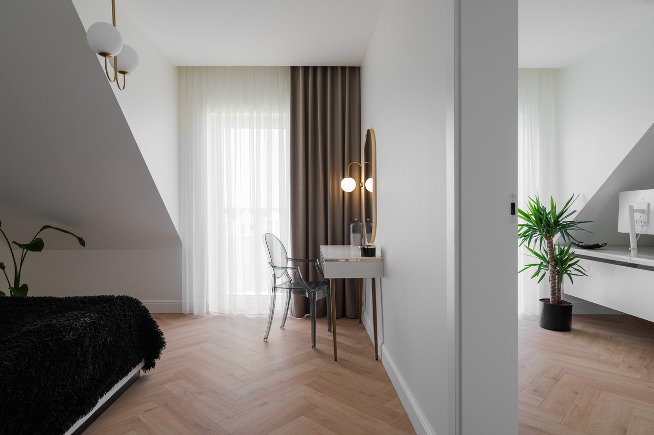 Nowoczesne wnętrze z eleganckim toaletką, stylową rośliną i oknem.