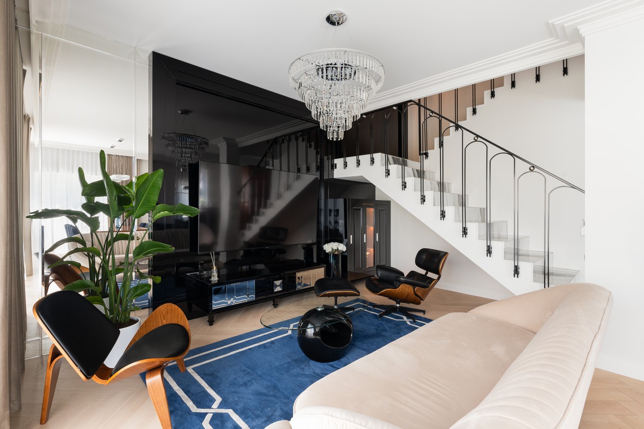 Stylowe wnętrze z elegancką klatką schodową i designerskim fotelem.