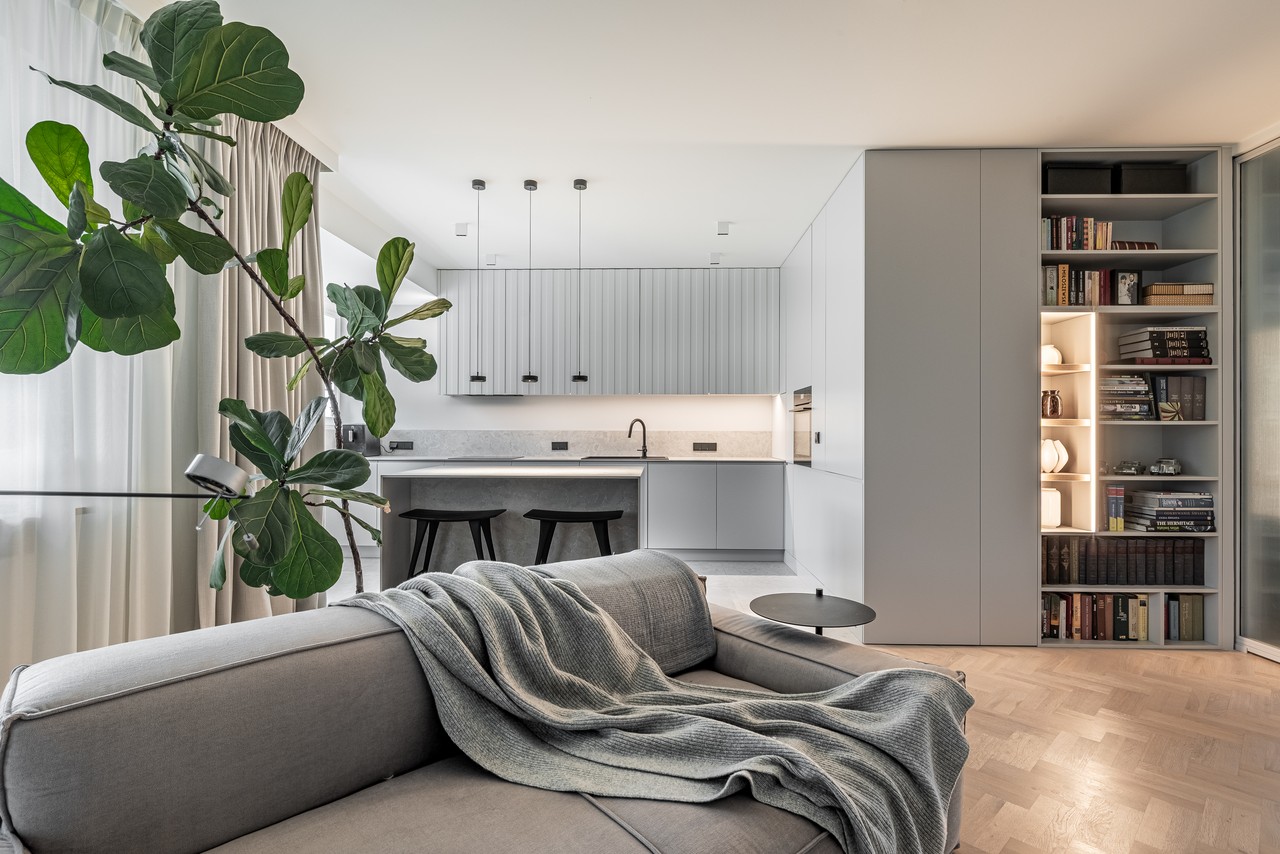 Stylowy salon z otwartą kuchnią i designerskimi detalami.