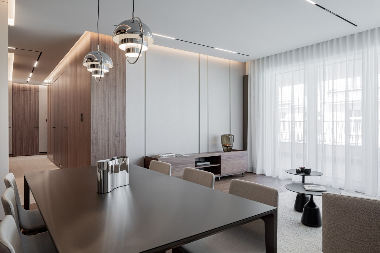 Elegancki salon z nowoczesnym oświetleniem i stylowym stołem.