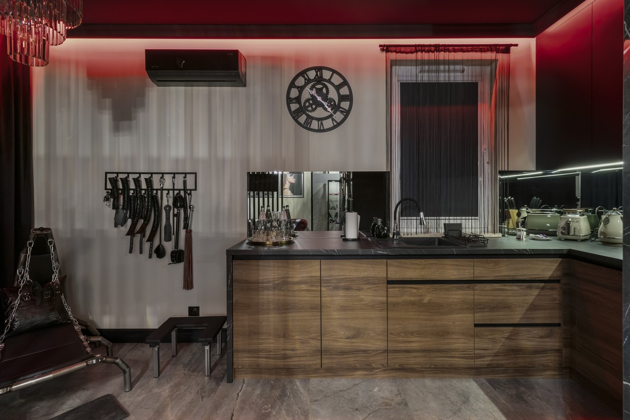 Kuchnia w stylu industrialnym z ciemnym drewnem i eleganckimi dodatkami.
