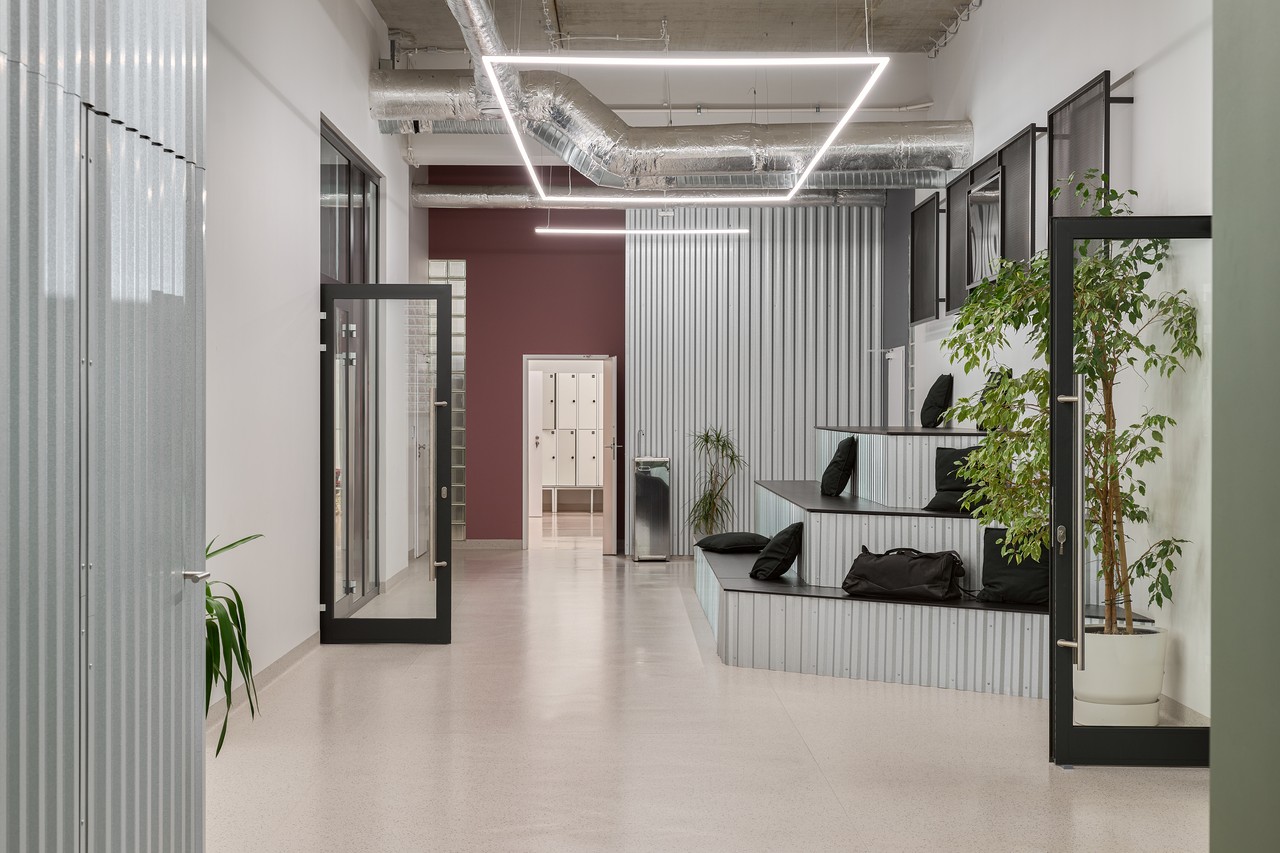 Nowoczesne wnętrze biurowe, stalowe panele i industrialne oświetlenie.