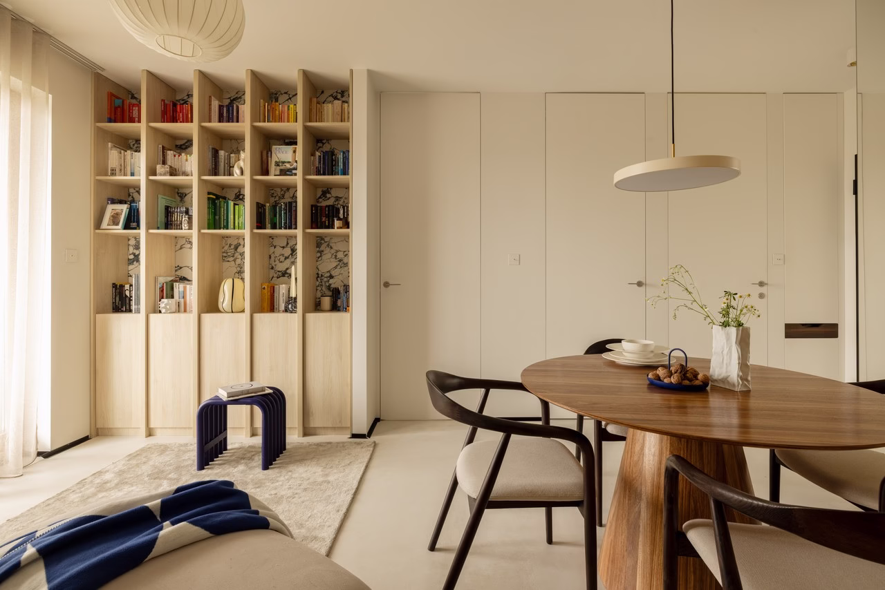 Nowoczesna jadalnia z drewnianym stołem i designerską półką.