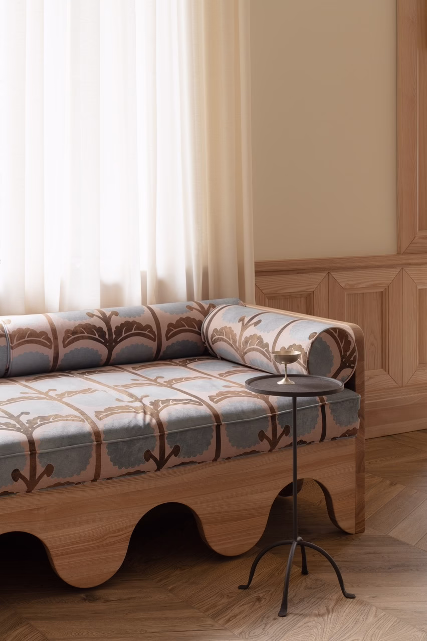 Elegancka kanapa z wzorem, stylowe wnętrze z drewnianymi panelami.