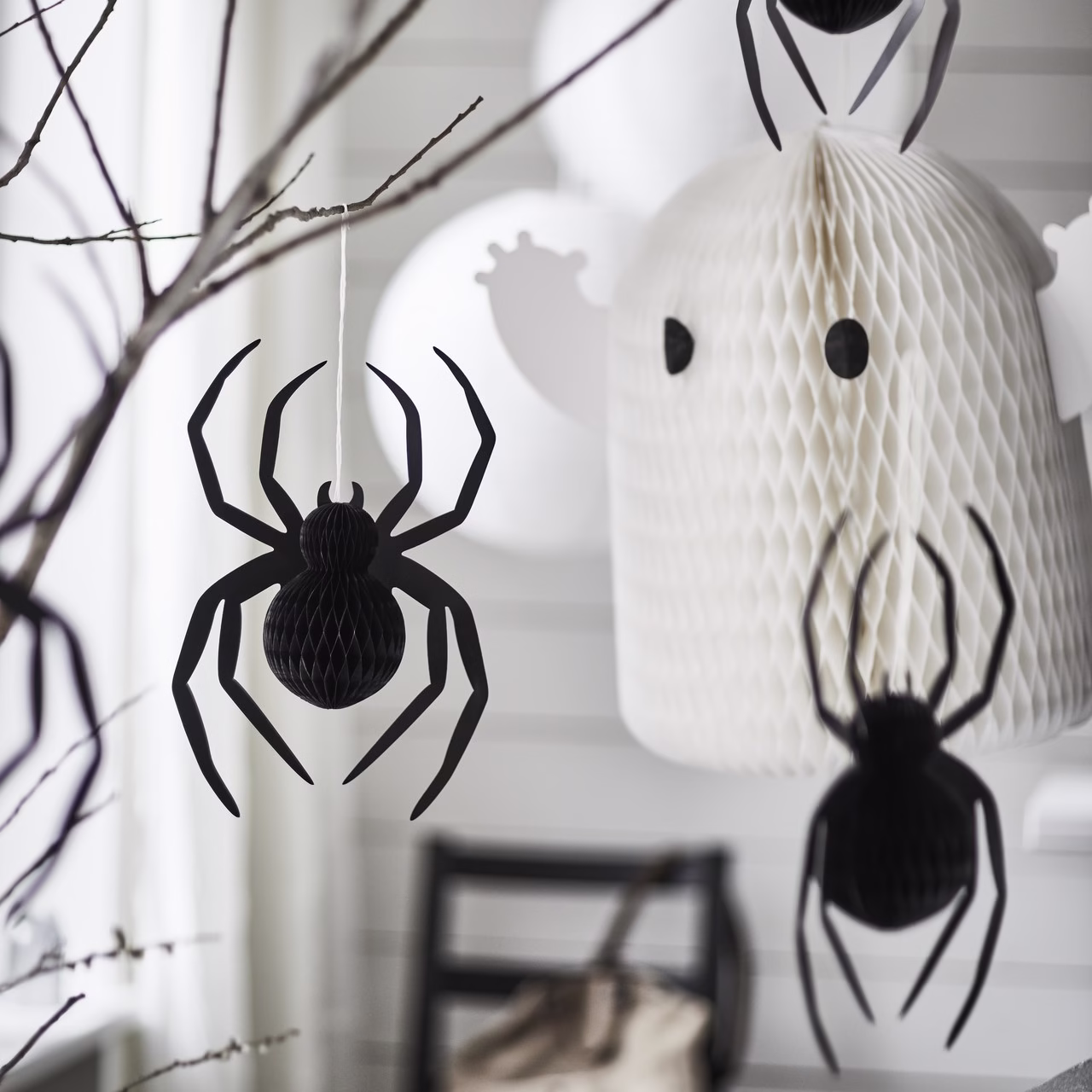 Papierowe ozdoby na Halloween: pająki i duchy w aranżacji wnętrza.