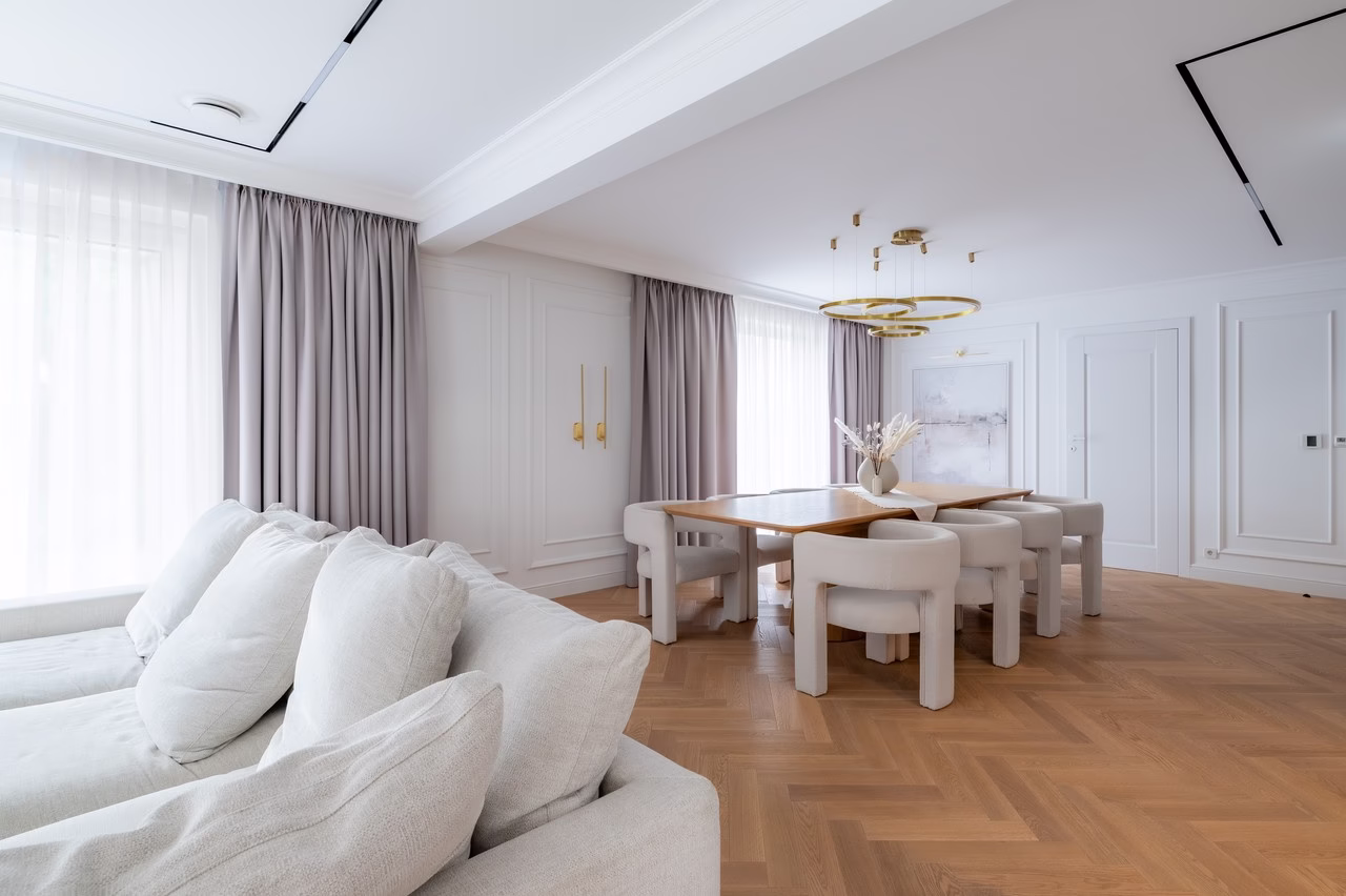 Nowoczesna jadalnia z drewnianą podłogą i designerskimi meblami.