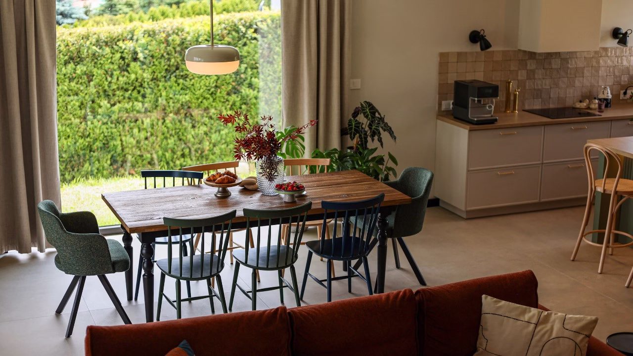 Jadalnia z rustykalnym stołem i nowoczesnym oświetleniem.