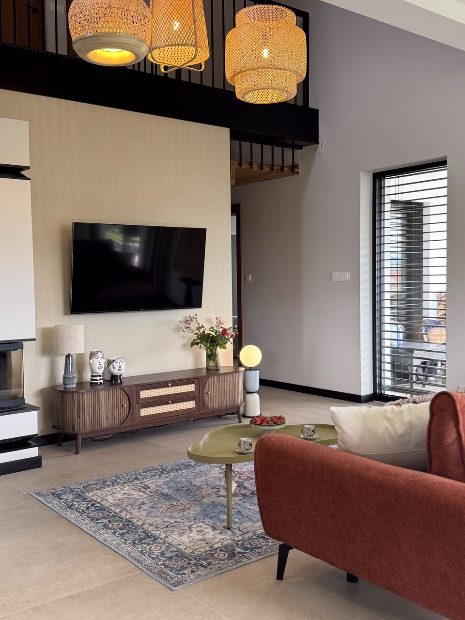 Salon z designerską lampą, nowoczesnym TV i eleganckim dywanem.