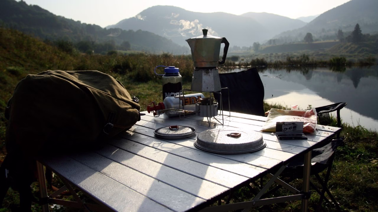 Przytulny stół kempingowy z widokiem na góry i jezioro.