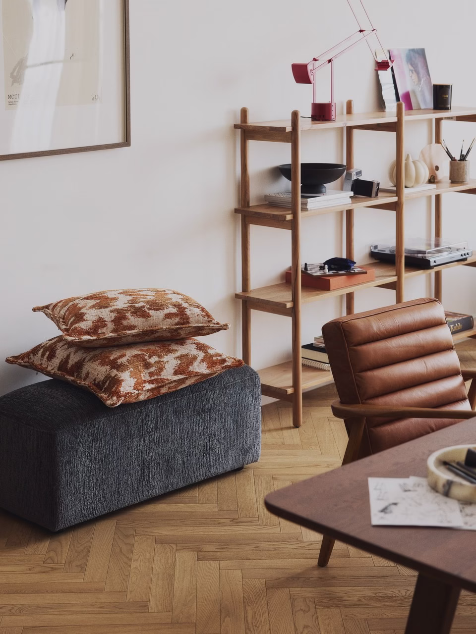 Elegancki salon z designerskim fotelem i półkami.