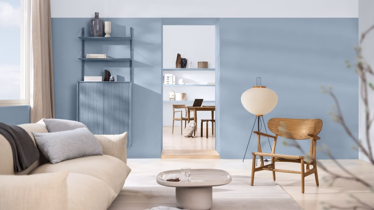 Jasne wnętrze z drewnianym krzesłem i niebieską ścianą.