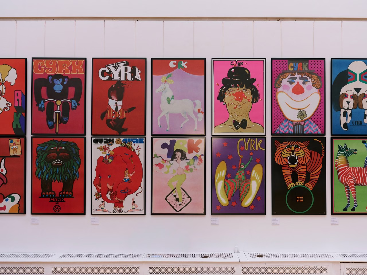 Kolorowe plakaty cyrkowe na ścianie galerii, pełne sztuki retro.