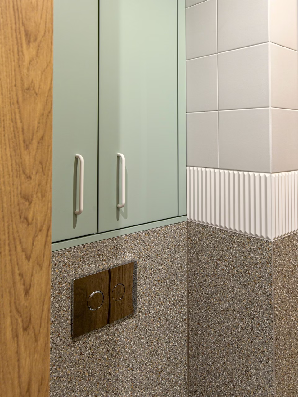 Miętowa szafka w skandynawskiej łazience z drewnianym i terrazzo wykończeniem.