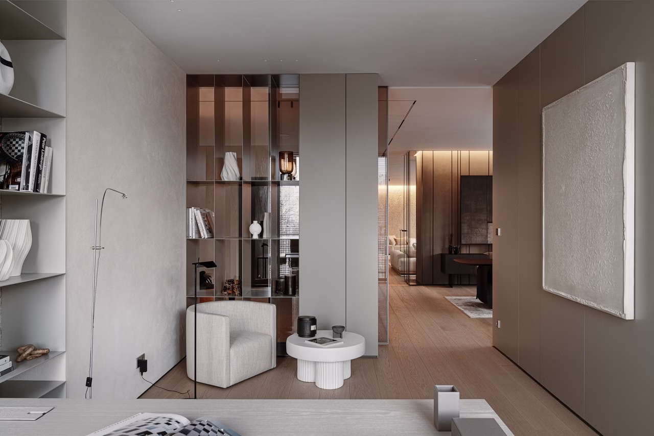 Minimalistyczny salon z beżowymi ścianami, nowoczesnymi regałami i designerskimi fotelami.