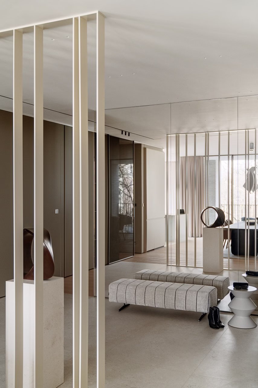 Nowoczesne wnętrze z minimalistycznymi detalami, beżowe przegrody i eleganckie meble.