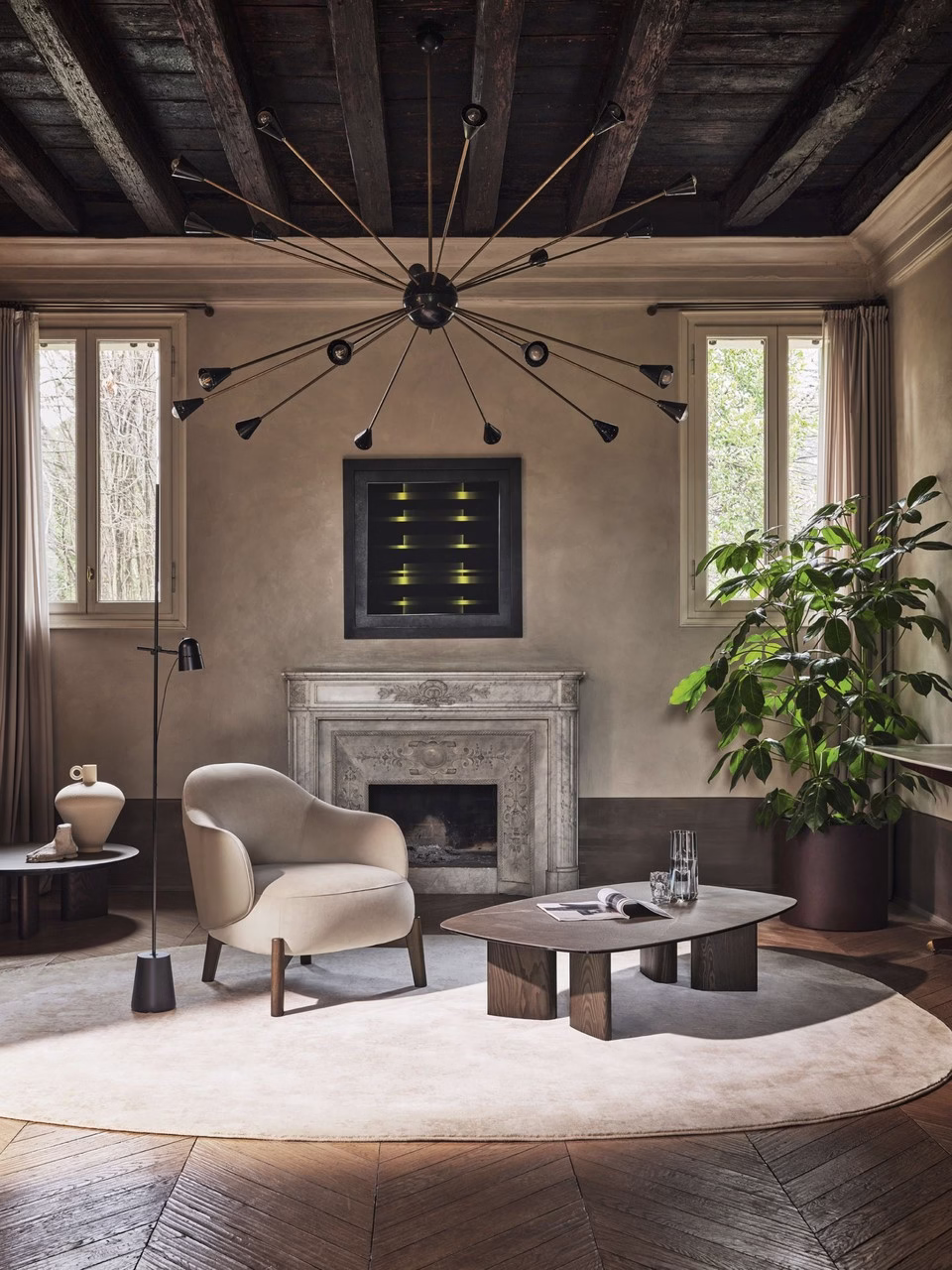 Elegancki salon z designerskim żyrandolem, marmurowym kominkiem i przytulnym fotelem.