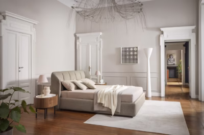 Elegancka sypialnia w beżach z designerskim żyrandolem i roślinnością.