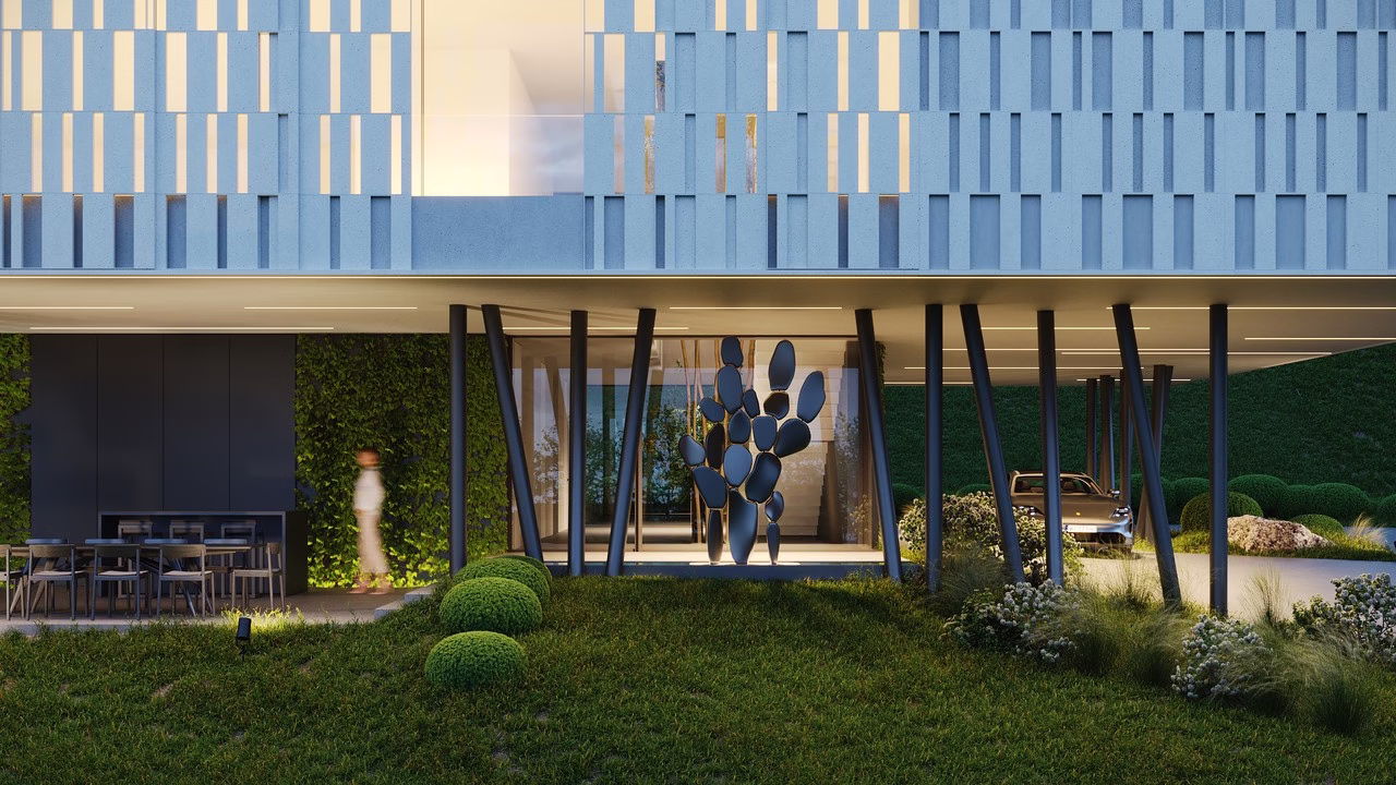 Nowoczesna architektura z zieloną fasadą, metalowymi filarami i designerską rzeźbą.