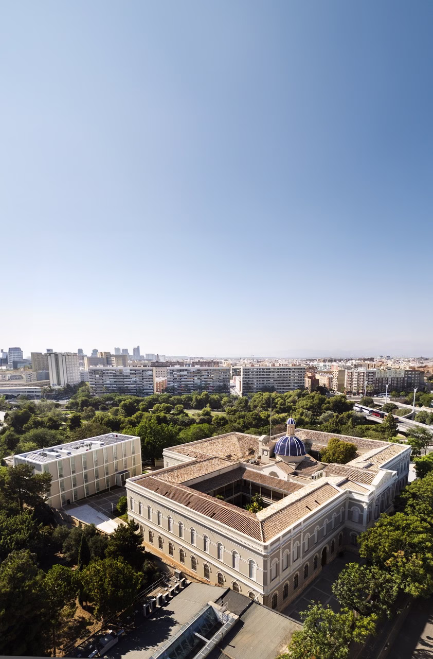 Widok na architekturę klasycystyczną z centralną kopułą i zielonym otoczeniem.