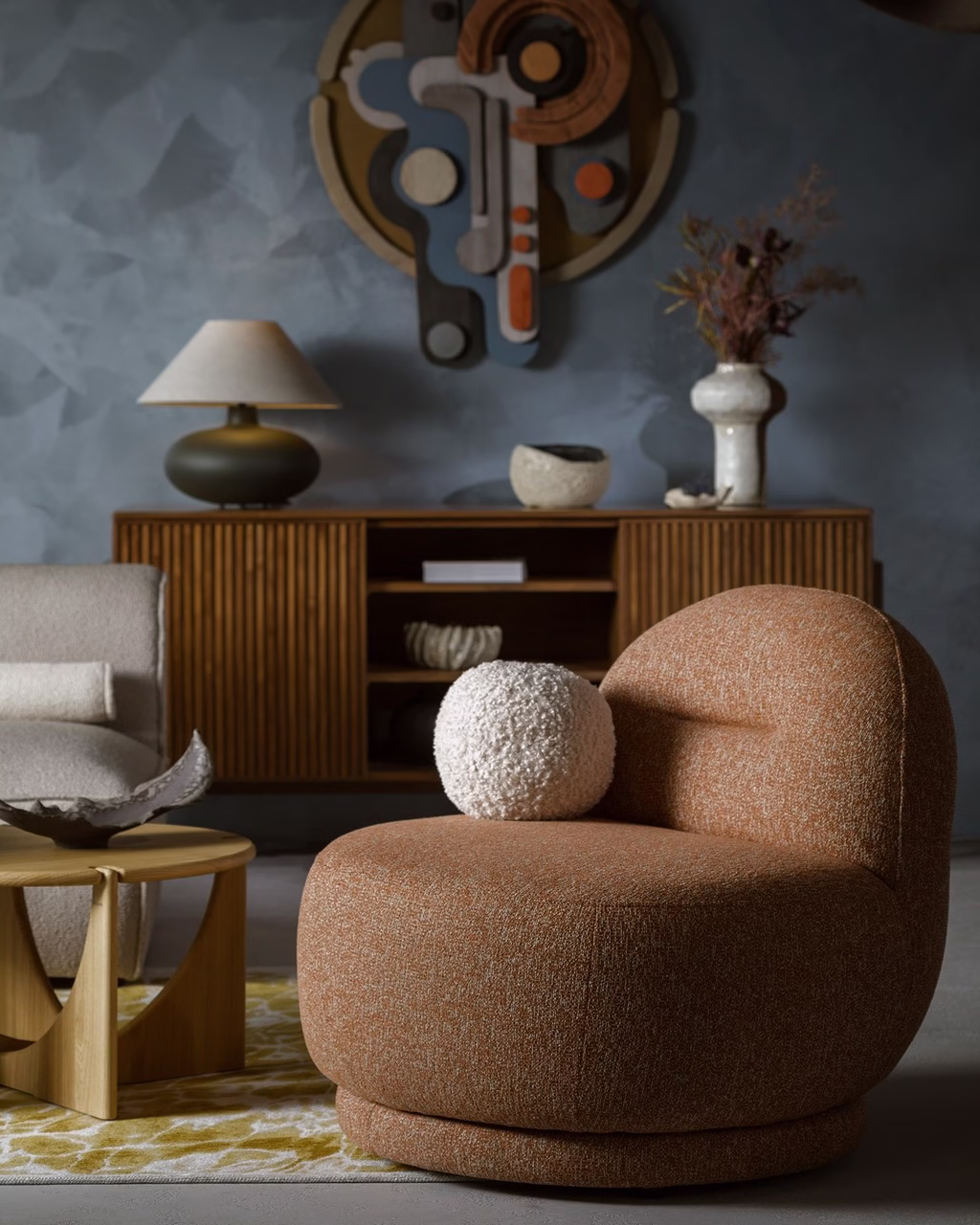 Przytulny salon z brązowym fotelem, designerskim stołem i dekoracjami.
