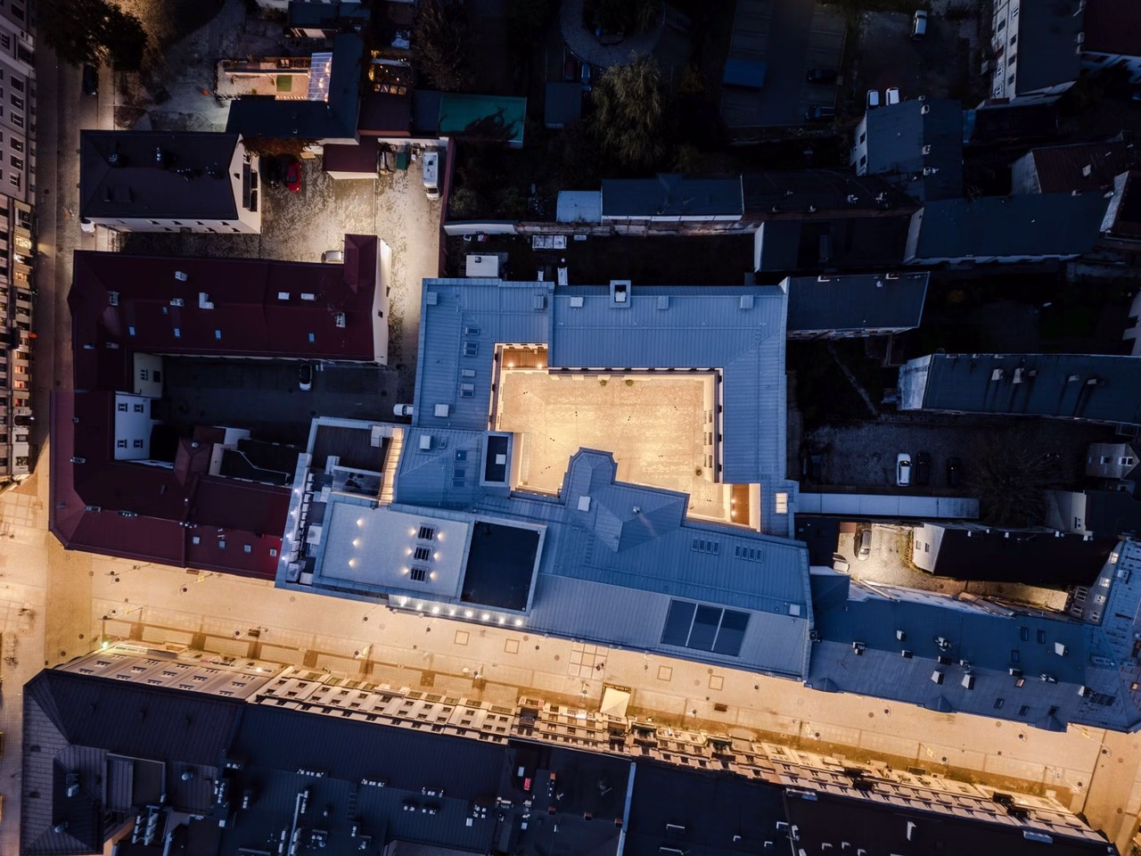 Widok z lotu ptaka na nowoczesną architekturę centrum miasta nocą.