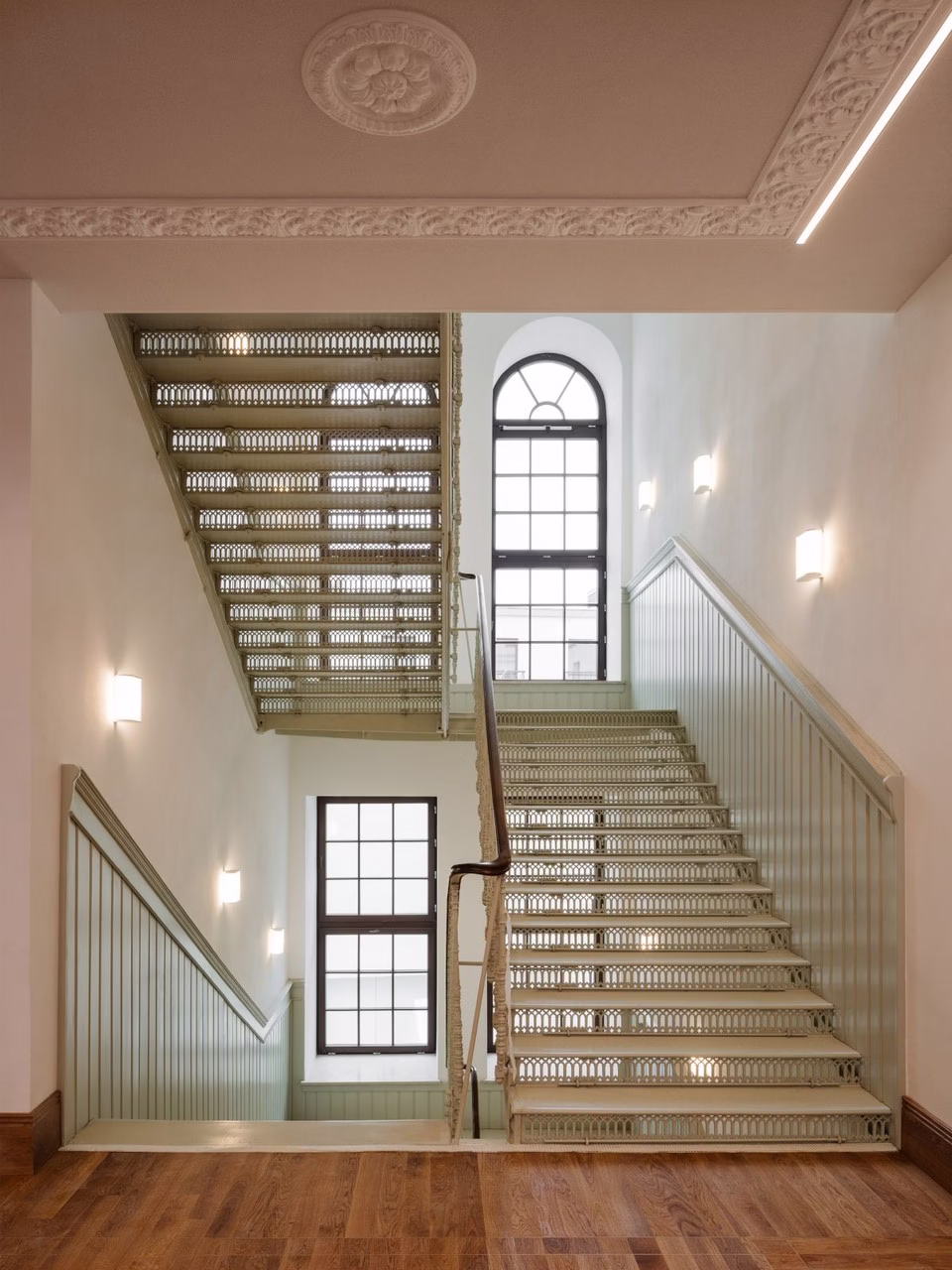 Metalowe schody w industrialnym stylu z ozdobnym sufitem i drewnianą podłogą.