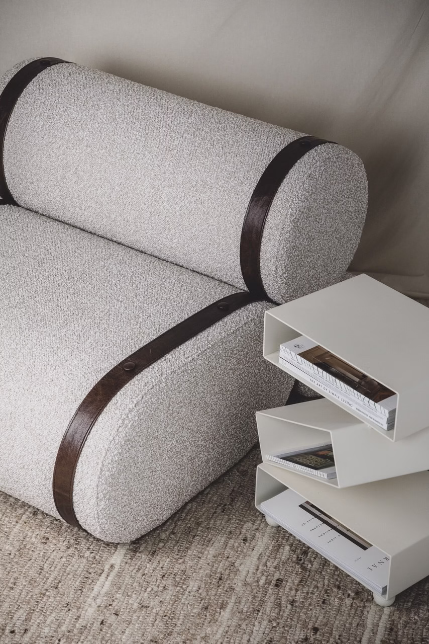 Jasna sofa z ciemnymi pasami, nowoczesny stolik, dywan z juty.