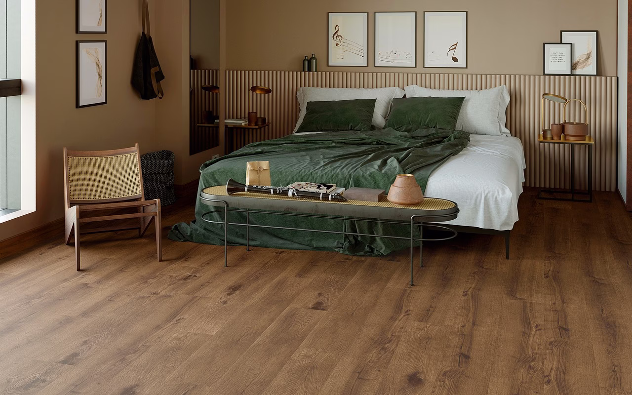 Stylowa sypialnia z zieloną pościelą, drewnianą podłogą i eleganckimi dekoracjami.
