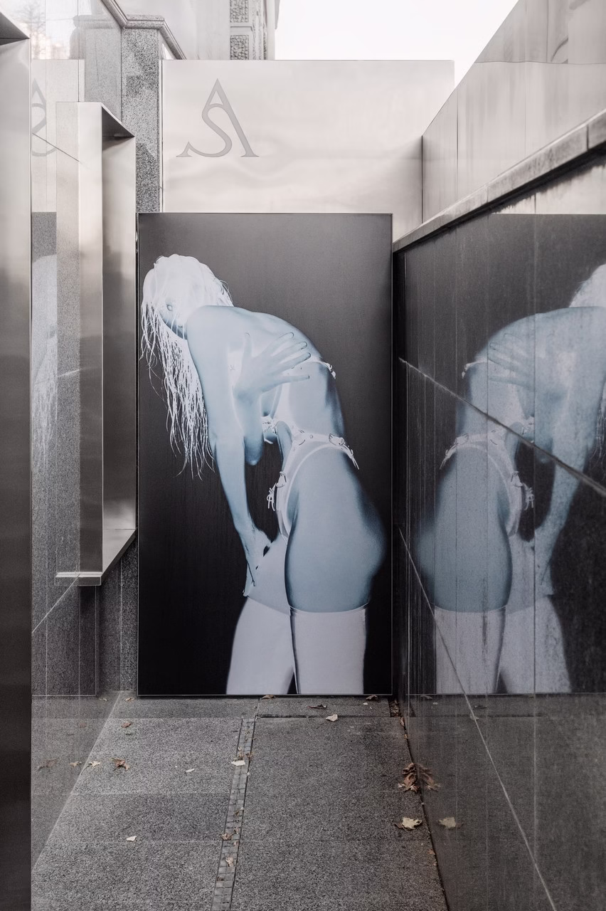 Nowoczesny korytarz z czarno-białą grafiką kobiety na ścianie.